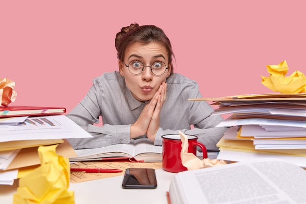 Student zit aan een bureau vol boeken