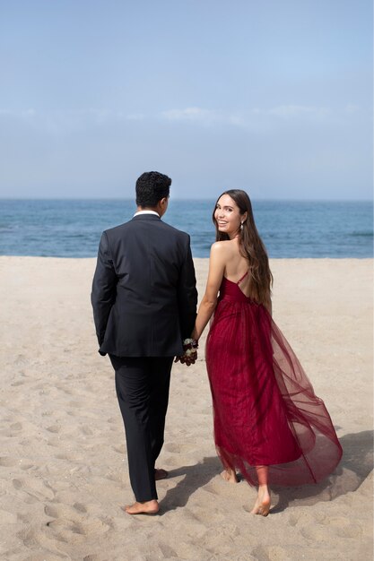 Studenten in galakleding op het strand