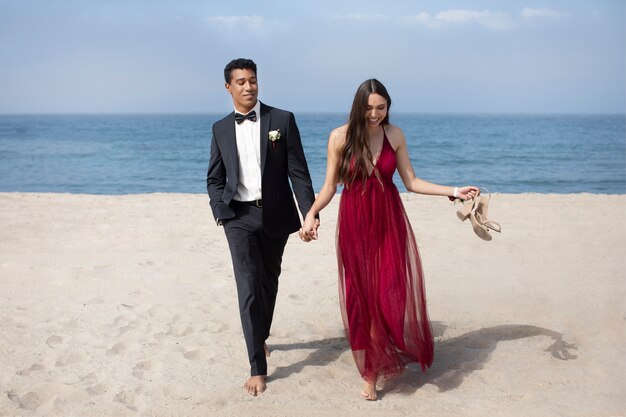 Studenten in galakleding op het strand