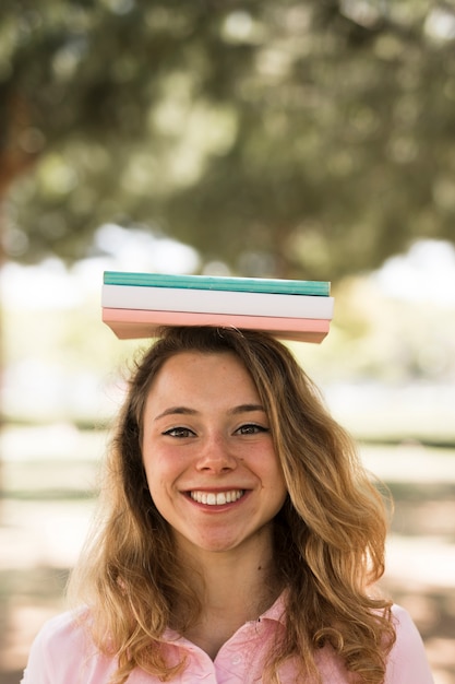 Gratis foto studentenvrouw met boeken op hoofd