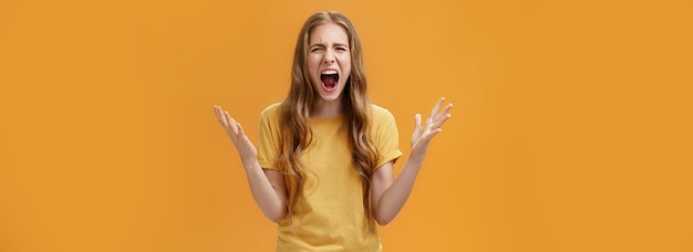 Gratis foto studio-opname van een jonge vrouw tijdens ruzie die haar geduld verliest terwijl ze onder druk staat en pissig schreeuwt l