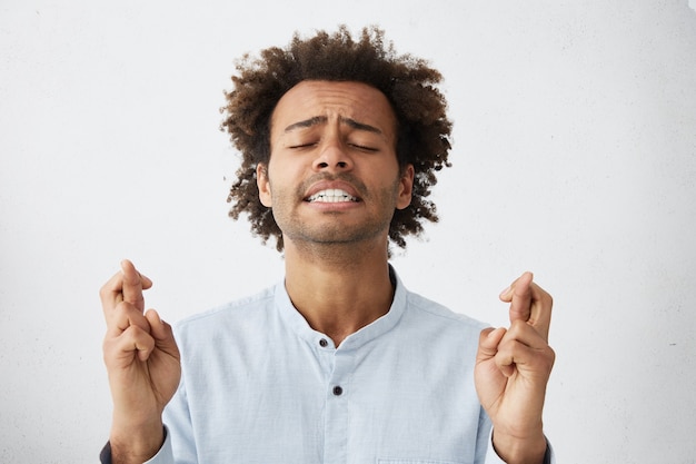 Gratis foto studio portret van grappige bebaarde jonge student die geluk wenst