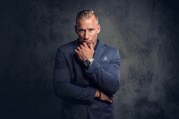 Studio portret van stijlvolle blonde man gekleed in een blauw pak.