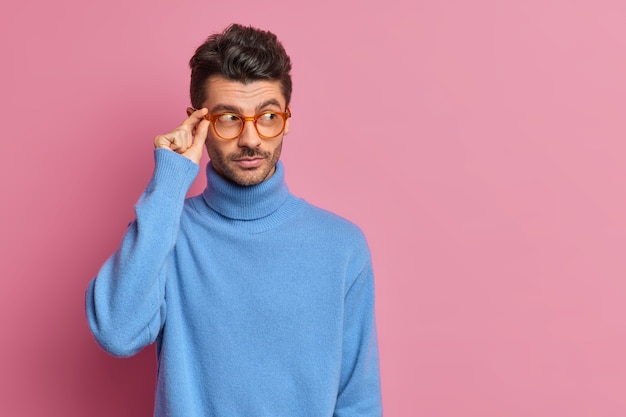 Studio shot van doordachte europese man peinzend geconcentreerd opzij