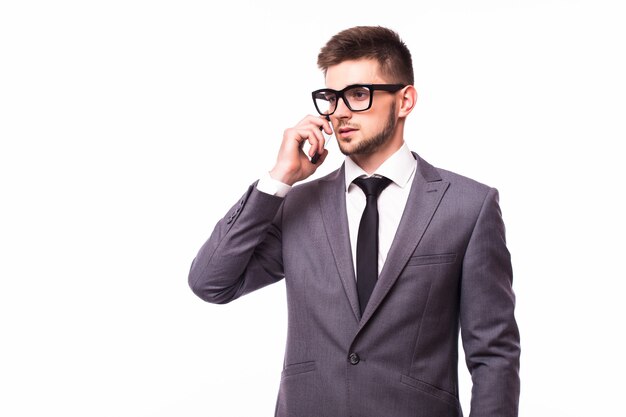 Studio shot van jonge zakenman met bril praten op mobiele telefoon