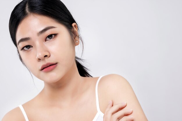 Studio shot van mooie jonge Aziatische vrouw met schone frisse huid op witte achtergrond Gezichtsverzorging Gezichtsbehandeling Cosmetologie schoonheid en spa