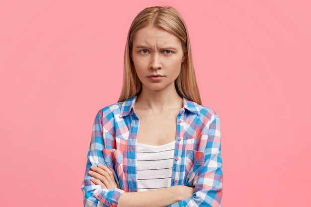 Studio shot van mooie jonge vrouw heeft een norse uitdrukking