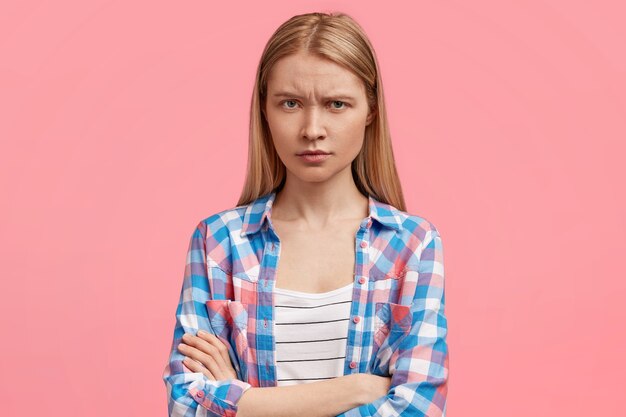 Studio shot van mooie jonge vrouw heeft een norse uitdrukking