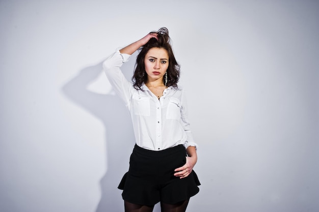 Gratis foto studioportret van donkerbruin meisje in witte blouse op witte background