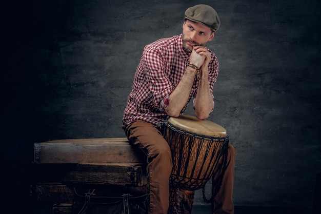 Studioportret van een man speelt op ethische houten trommels.