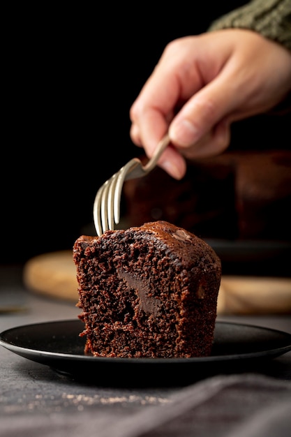 Stuk chocoladetaart in een zwarte plaat