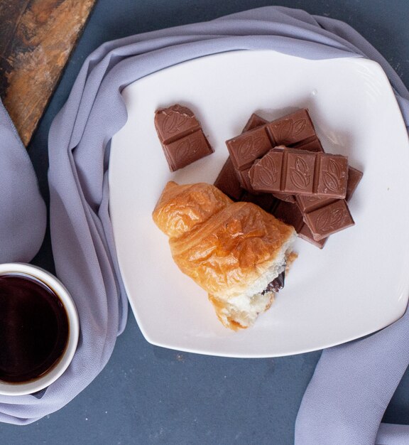 stuk croissant en chocoladereep in een witte plaat