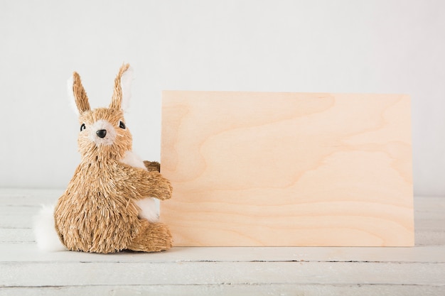 Stuk speelgoed konijn dichtbij houten raad