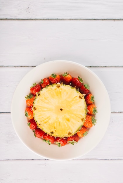 Stuk van ananas op aardbeien