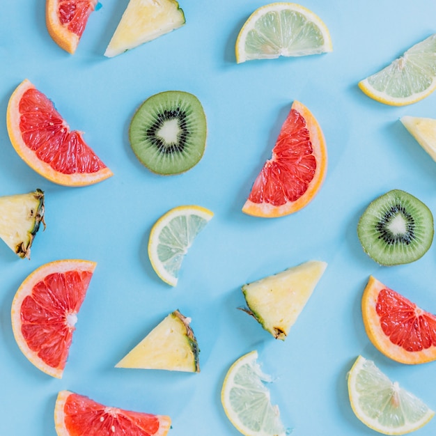 Stukken van ananassen en kiwi dichtbij citrusvruchten