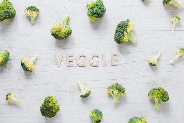 Stukken van broccolioregeling met het veggie van letters voorzien op houten lijst