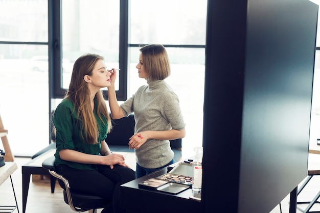 Gratis foto stylist die met model in studio werkt