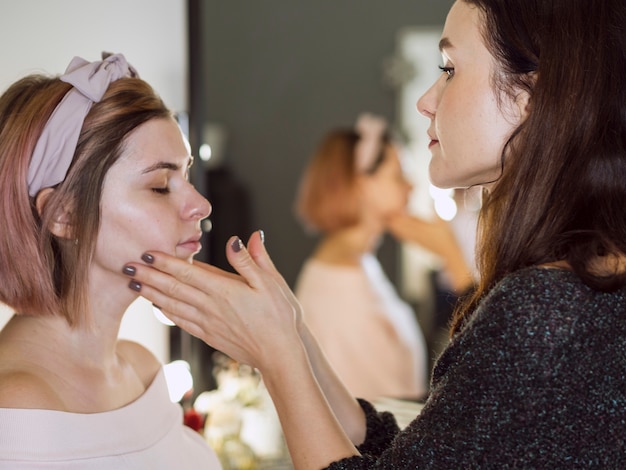 Stylist masseren gezicht van klant