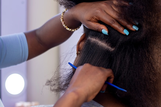 Stylistvrouw die voor haar cliëntafrohaar zorgt