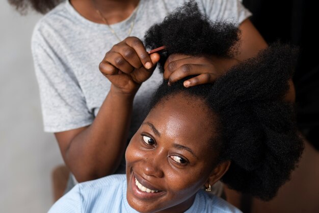 Stylistvrouw die voor haar cliëntafrohaar zorgt