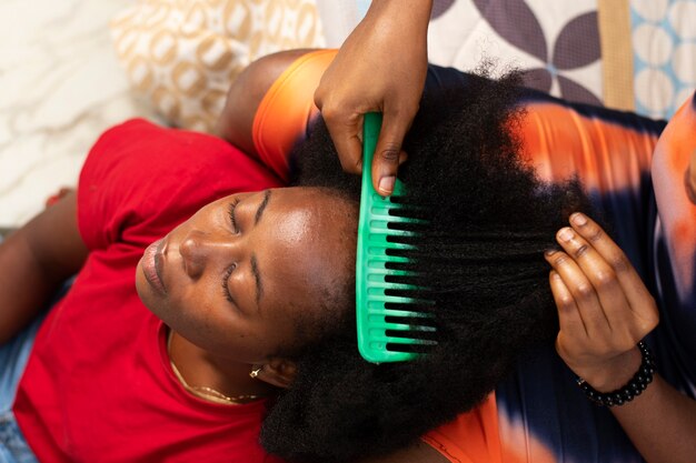 Stylistvrouw die voor haar cliëntafrohaar zorgt