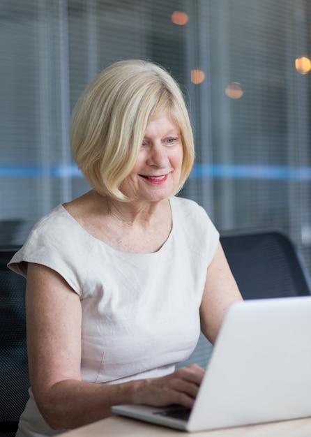 Succesvolle senior zakenvrouw werken op laptop