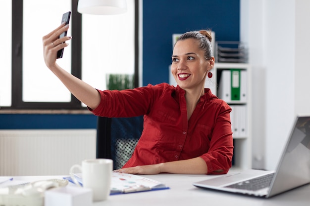 Succesvolle zakenvrouw die plezier heeft bij het maken van selfies Gratis Foto