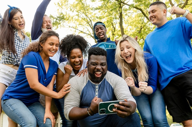 Supporters kijken hoe hun team de wedstrijd wint op een mobiele telefoon