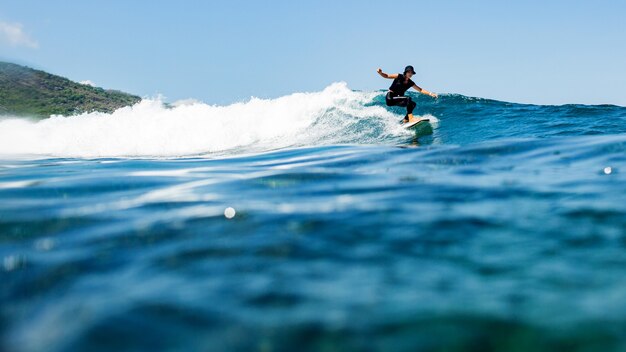 Surfer op een blauwe golf.