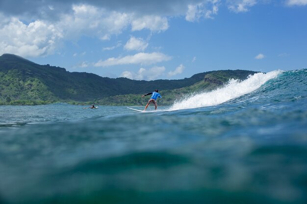 Surfer op een blauwe golf.