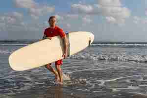 Gratis foto surfer wandelen langs het strand. bali