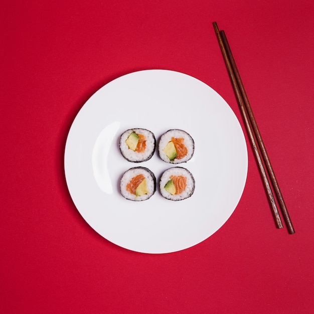 Gratis foto sushi en eetstokjes op rood