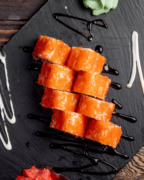 Gratis foto sushi rolletjes met tã â¾biko kaviaar geserveerd met gember en wasabi