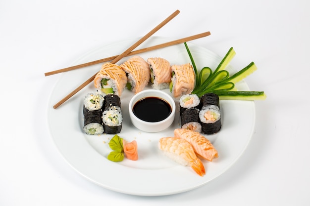 Sushi set met sojasaus in het midden van een bord en eetstokjes