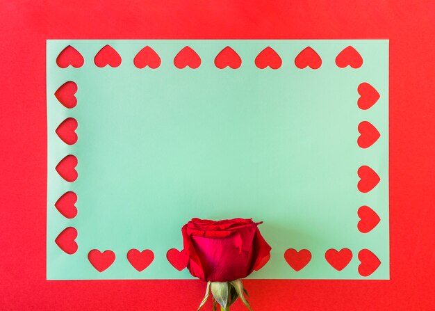 Symbolen van hart op blauw papier in de buurt van roos