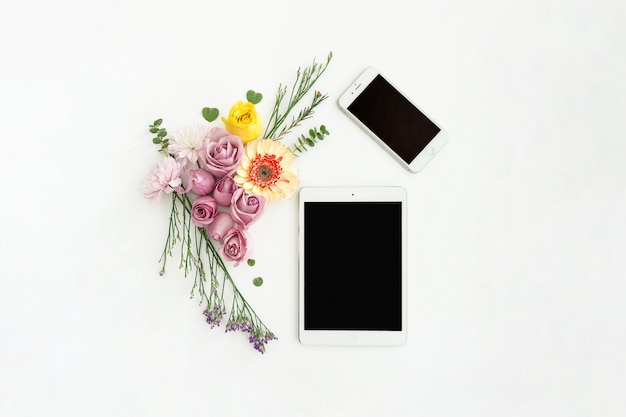 Tablet en mobiele telefoon met decoratieve bloemen