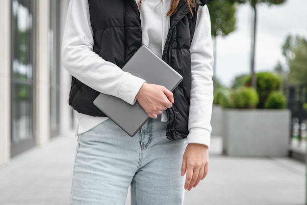 Tablet in de handen van een vrouw op een wazig achtergronddeel van het lichaam