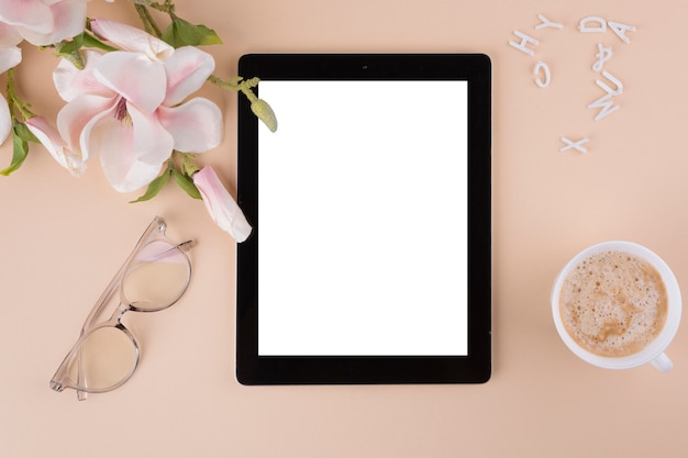 Tablet met koffiekop en bloemen