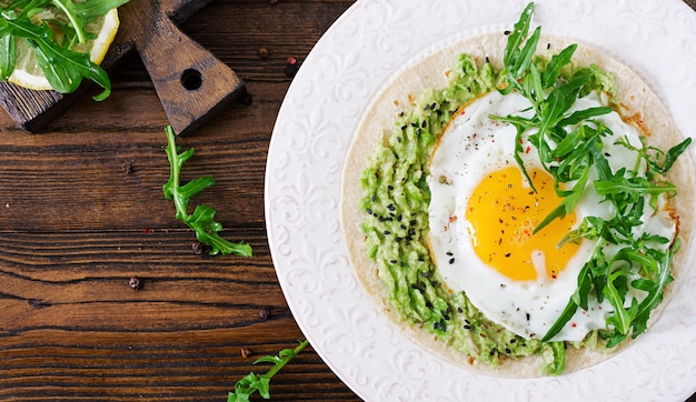 Taco's met guacamole, gebakken ei en rucola. Gezond eten. Handig ontbijt. Plat leggen. Bovenaanzicht