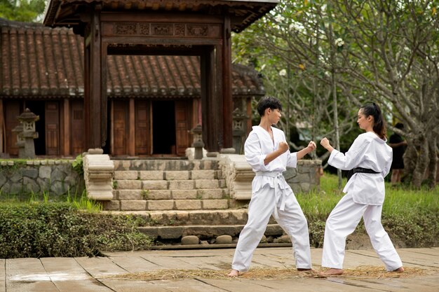 Taekwondo training buiten in de natuur met twee personen