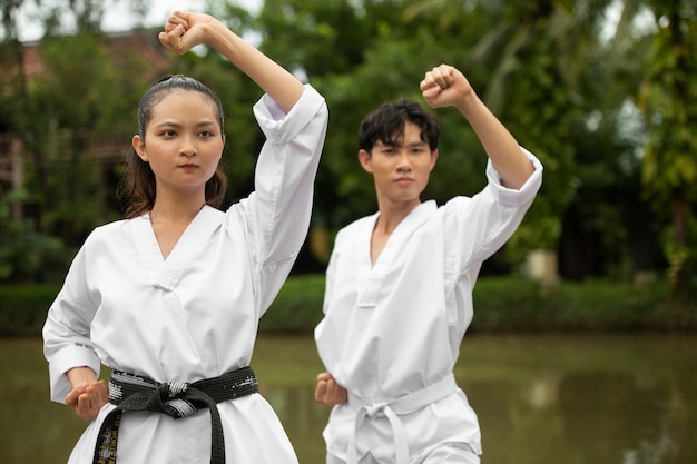 Taekwondo training buiten in de natuur met twee personen