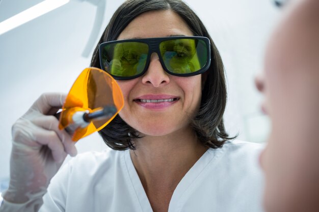 Tandarts die patiëntentanden met tand het genezen licht onderzoeken