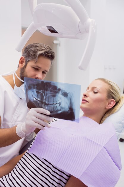 Tandarts die röntgenstraal toont aan de patiënt