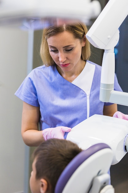 Gratis foto tandarts die x-ray machine in kliniek met behulp van