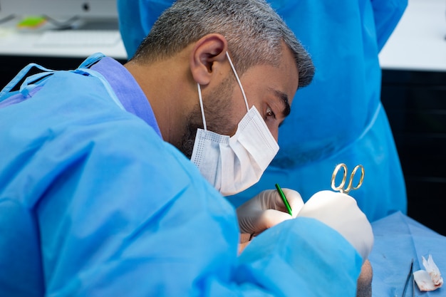 Tandarts tijdens de operatie in de tandheelkundige kliniek