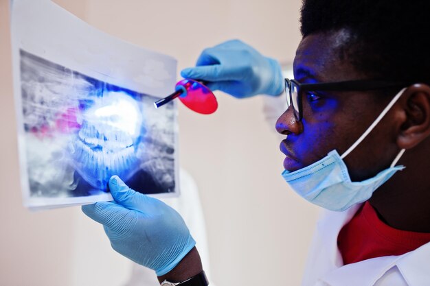 Tandartspraktijk en dokterspraktijkconcept Close uo van handen professionele Afro-Amerikaanse arts bij tandheelkunde medisch wijzend op tanden Xray