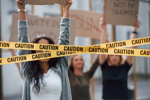 Tape voor de ogen van het meisje. Een groep feministische vrouwen protesteert buitenshuis voor hun rechten