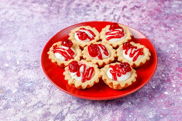 Tartlets met witte chocolade vulling en bessenjam bovenop.