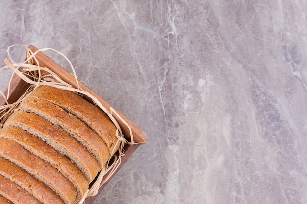 Tarwebrood op een rietje in een doos, op de marmeren tafel.