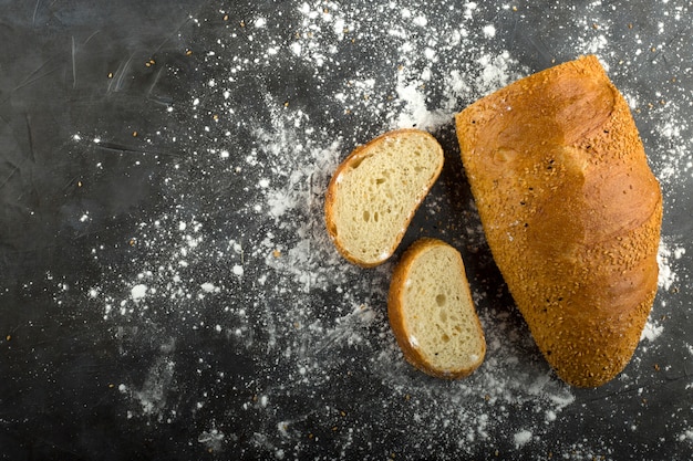 Tarwebrood sneetjes en bloem op de grond